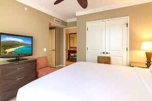Ein Hotelzimmer mit einem Bett, einem Fernseher auf einer Holzkommode, einer Tür und einer Lampe.
