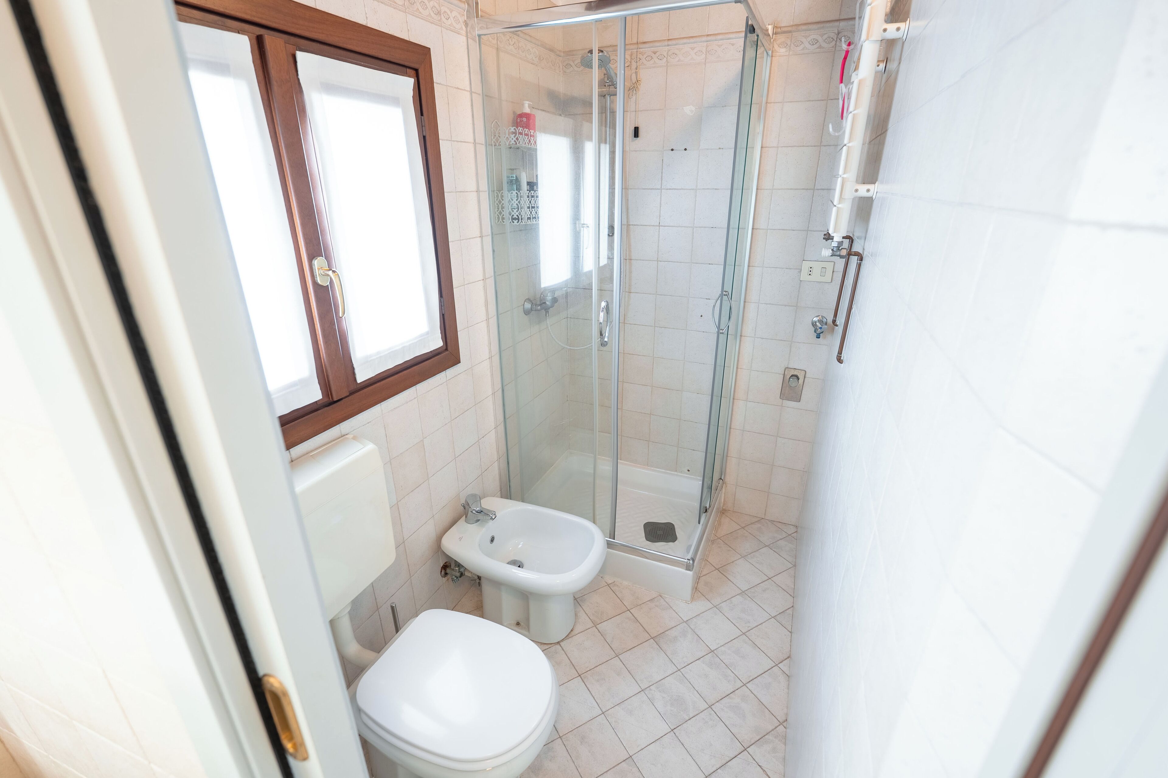 Ein Badezimmer mit einer Duschkabine, einer Toilette und einem Bidet.