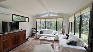 A spacious living room with a large TV, a wooden cabinet, and a sofa set. - Countryside villa with swimming pool (Lambesc)