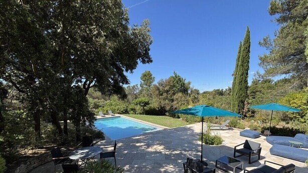A poolside area with a stone patio, outdoor furniture, and umbrellas. - Countryside villa with swimming pool (Lambesc)