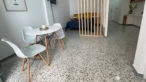 A modern room with a dining area, a bed, a TV, and a wooden partition. - Vacation Studio 'Puerto Centro House' with Balcony and Wi-Fi (Puerto de la Cruz)