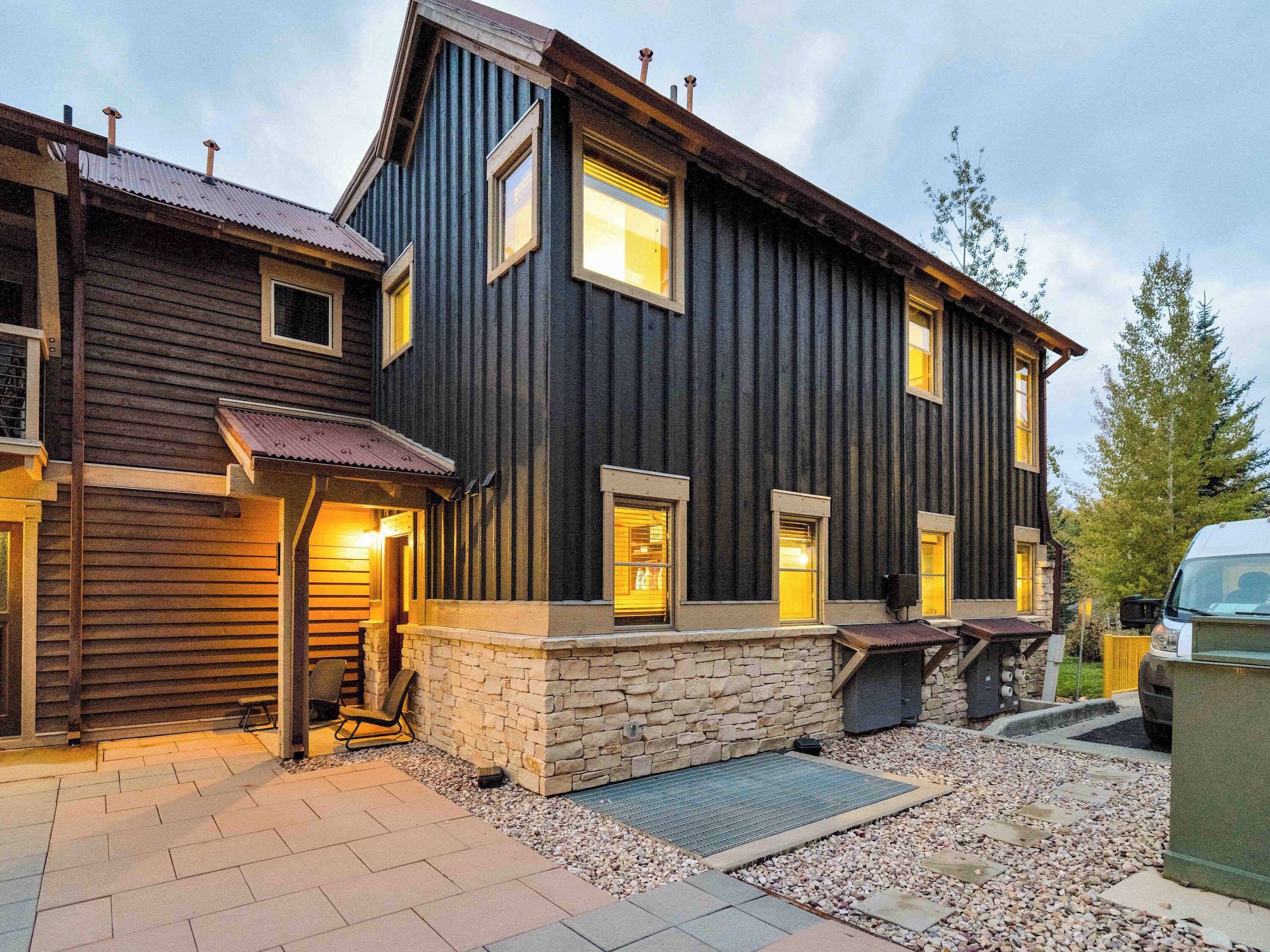 A two-story house with a stone foundation and wooden siding.