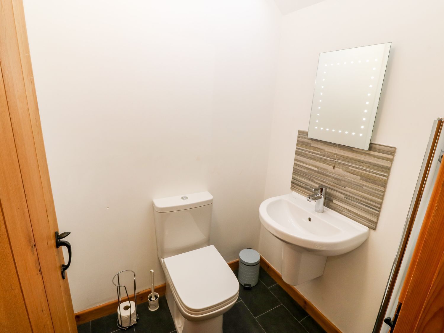 Ein kleines Badezimmer mit Toilette, Waschbecken und Spiegel.