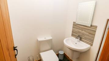 Ein kleines Badezimmer mit Toilette, Waschbecken und Spiegel.