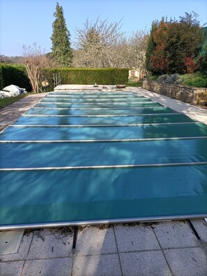 Une piscine bordée de pierres, avec une eau d’un bleu limpide.