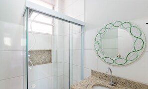 A modern bathroom with a glass shower enclosure, a granite countertop, and a mosaic mirror. - Apt in Downtown 150m From the Sea Tib0404 (Guarapari)