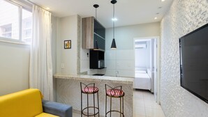 A modern kitchen with a central island, bar stools, and pendant lighting. - Apt in Downtown 150m From the Sea Tib0404 (Guarapari)