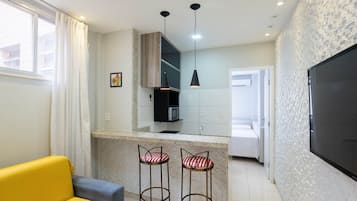 Una cucina moderna con isola centrale, sgabelli da bar e illuminazione a sospensione.