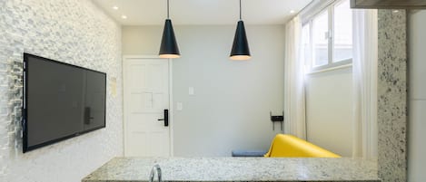 A modern kitchen with granite countertops, a built-in stove, and pendant lighting.