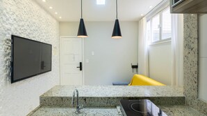 A modern kitchen with granite countertops, a built-in stove, and pendant lighting. - Apt in Downtown 150m From the Sea Tib0404 (Guarapari)