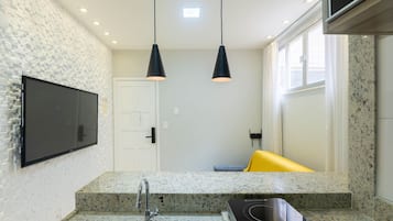 Una cocina moderna con encimeras de granito, estufa integrada e iluminación colgante.