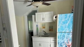 A kitchen with white cabinets, a gray countertop, and a ceiling fan. - Beaufort Bunkhouse (Beaufort)