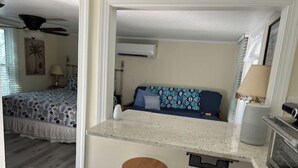 A compact kitchen with a bar stool, a microwave, and a small countertop. - Beaufort Bunkhouse (Beaufort)