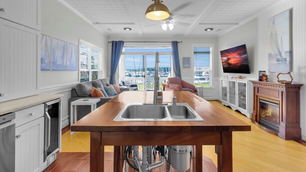 Una cocina moderna con una isla de madera, electrodomésticos integrados y un amplio ventanal con vistas.