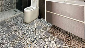 A modern bathroom with a shower, toilet, and vanity.