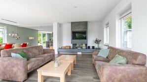Ein großzügiges Wohnzimmer mit zwei Sofas, einem Couchtisch und einem Kamin.