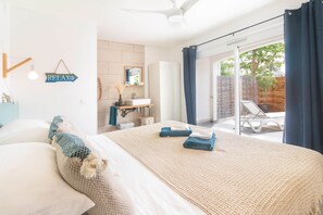 A bedroom with a bed, a bathroom with a sink and mirror, and a sliding glass door to a balcony.