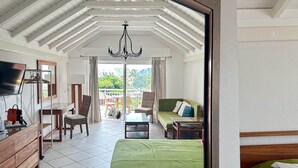 A hotel room with a balcony, a bed, a TV, a desk, and a chair. - Studio Palm Court with shared pool behind Orient Beach (Collectivity of Saint Martin)