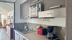 A modern kitchen with a Bosch microwave, a coffee maker, and a toaster. - Studio Palm Court with shared pool behind Orient Beach (Collectivity of Saint Martin)