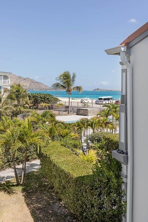 Ein Resort mit Pool, Palmen und Blick auf Strand und Meer.