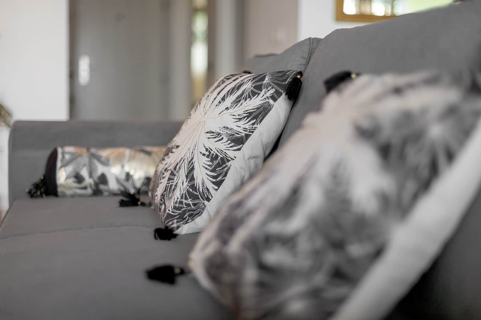 Um sofá com almofadas estampadas em um interior moderno.