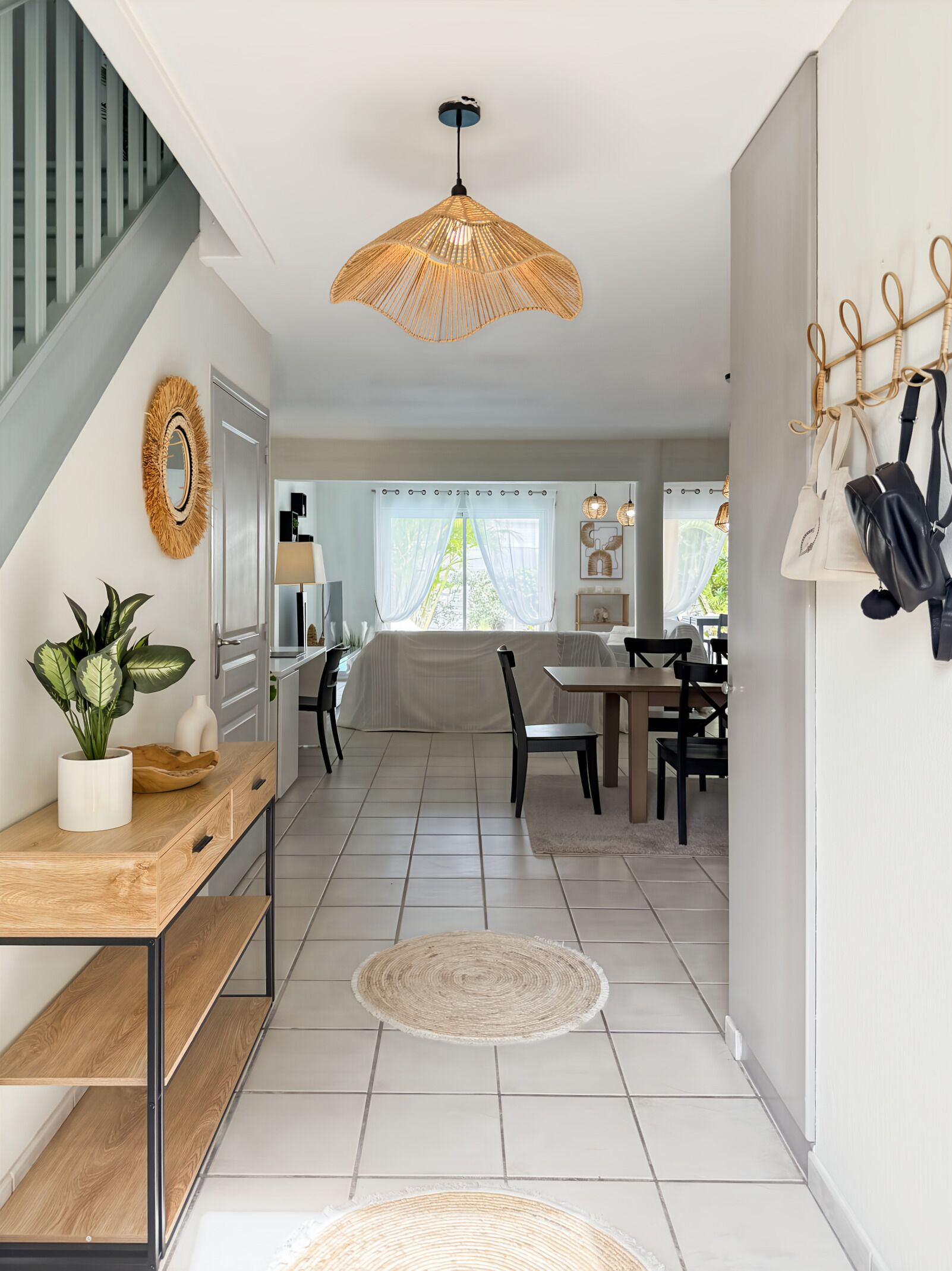 A modern kitchen with a dining area, a staircase, and a view of the outdoors.