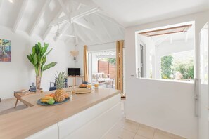 A modern kitchen with a wooden countertop, a television, and a dining area with a view of the outdoors.