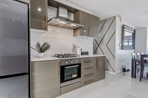A modern kitchen with stainless steel appliances, a gas stove, and a built-in oven.