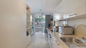 A modern kitchen with a large window, a built-in oven, and a sink. - Harbour Bridge Retreat | No Loadshedding (Cape Town)