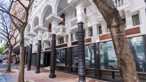 A building with white facades, large windows, and black columns. - Venice-Inspired Penthouse with City Views (Cape Town)