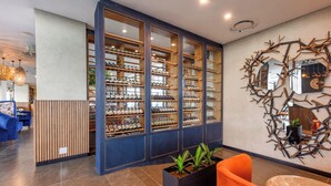 Un interior moderno con una bodega, un panel de madera y un espejo decorativo.