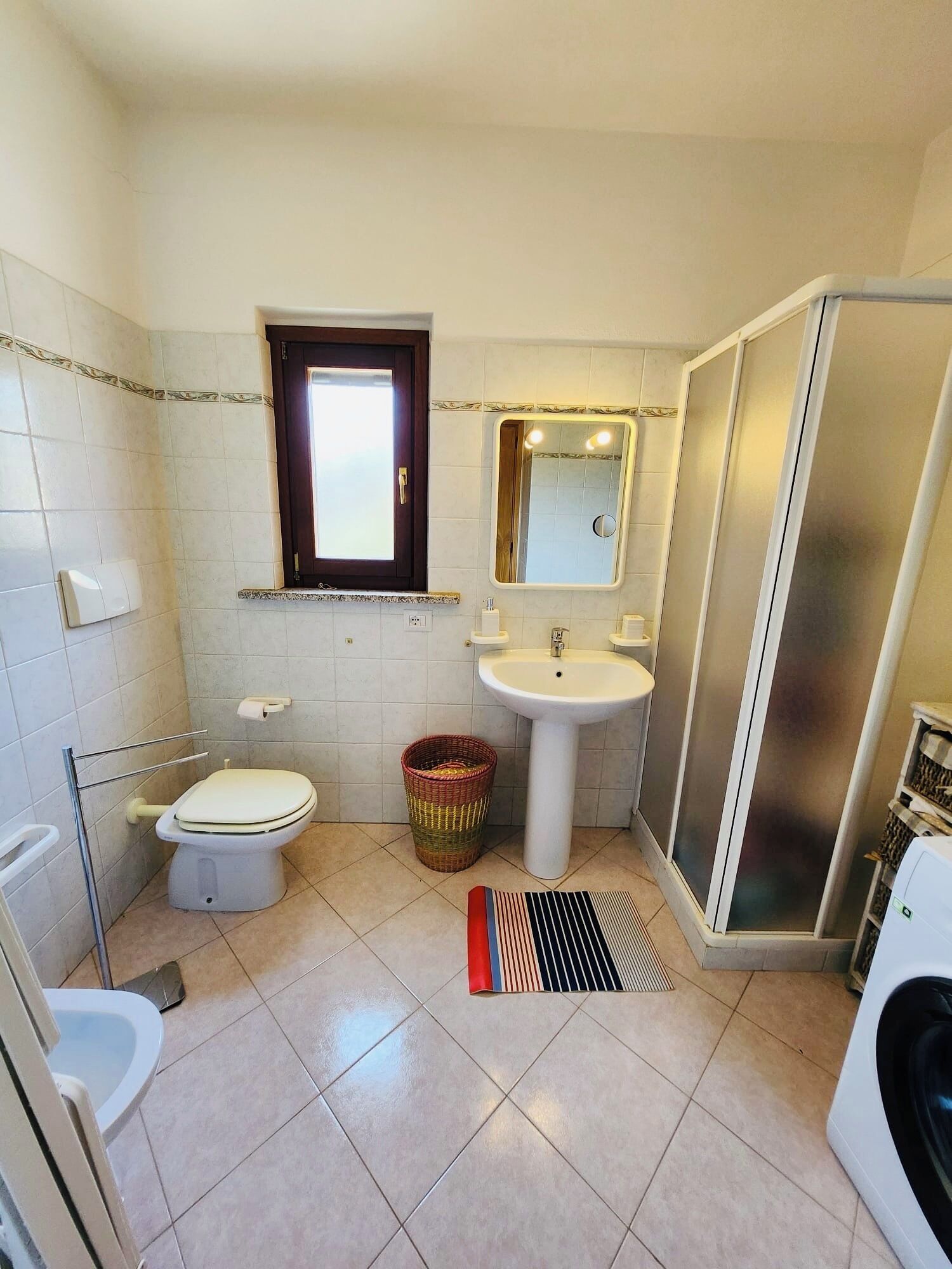 Une petite salle de bain comprenant des toilettes, un lavabo et une douche.