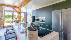 A modern kitchen with a large island, stainless steel appliances, and a view of the outdoors. - Luxurious and Sustainable 6-person Holiday Villa (De Koog)