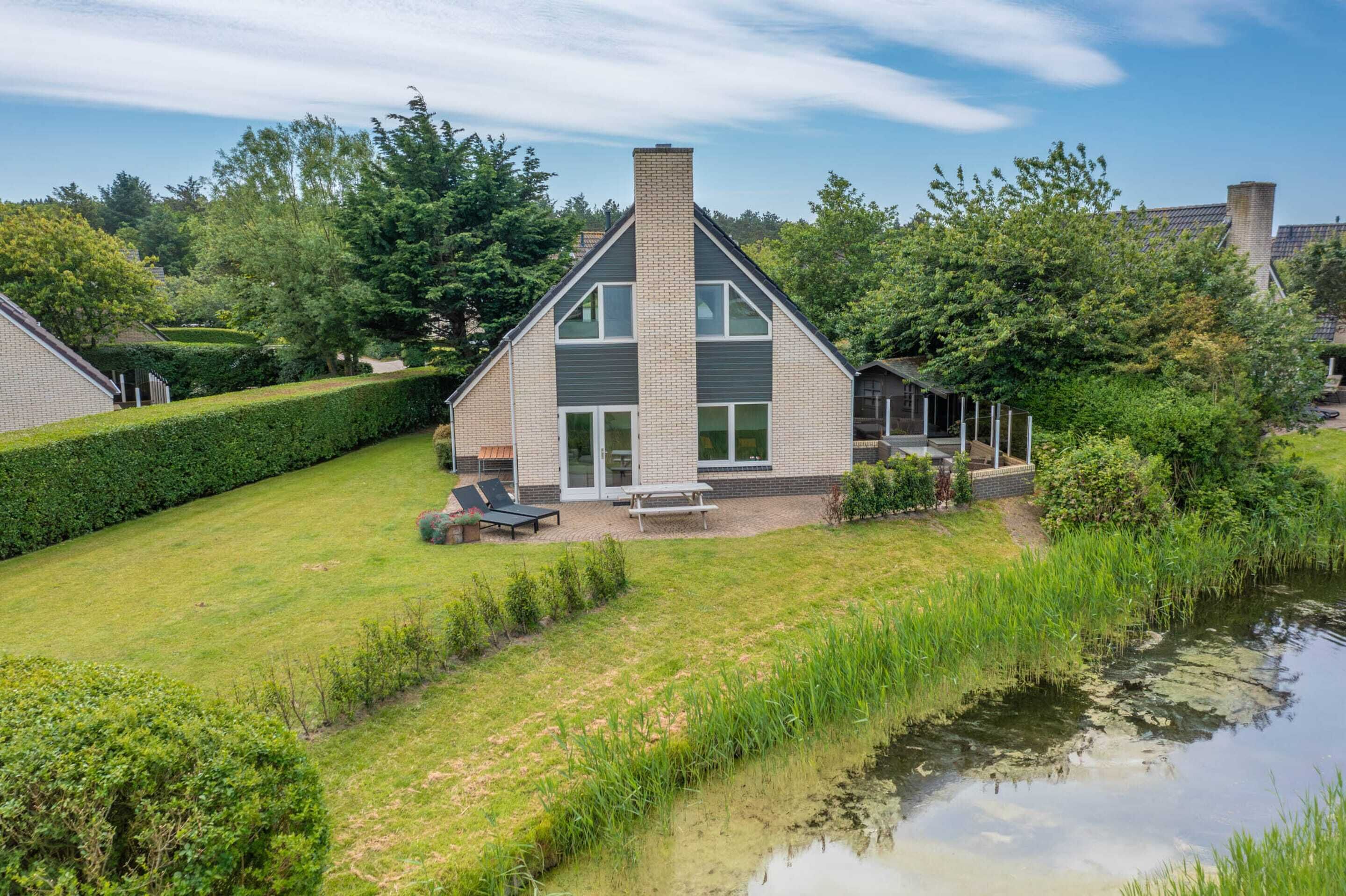 A modern house with a large front yard, a swimming pool, and a well-maintained garden.