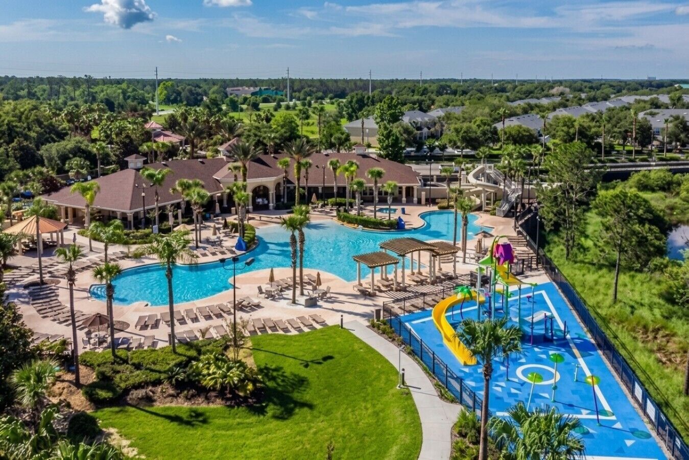 Un complexe hôtelier doté d’une grande piscine, de chaises longues et d’un toboggan aquatique.