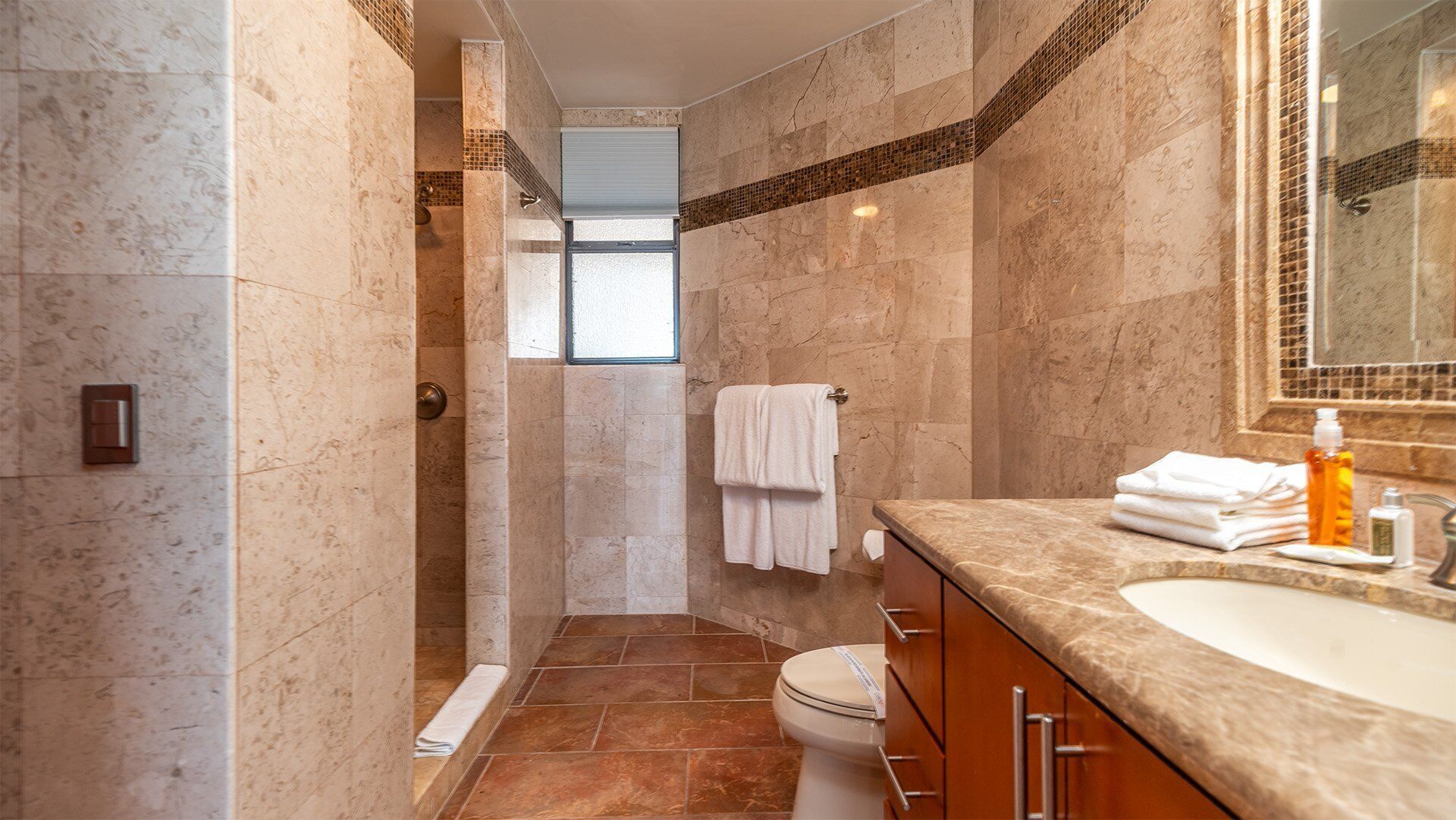 Une salle de bain moderne équipée d’une douche, de toilettes et d’un lavabo.