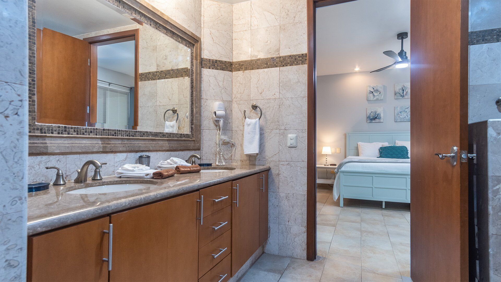 Une salle de bain avec un lavabo en marbre, un sèche-cheveux et un porte-serviettes.