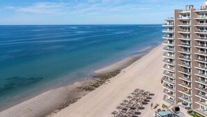 A high-rise hotel with multiple balconies overlooking a beach and the sea. - Las Palomas Beach and Golf Resort (Puerto Peñasco)