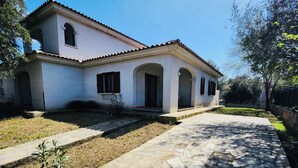 A two-story house with a stone pathway leading to the entrance. - Casa Vacanza Salix (San Teodoro)