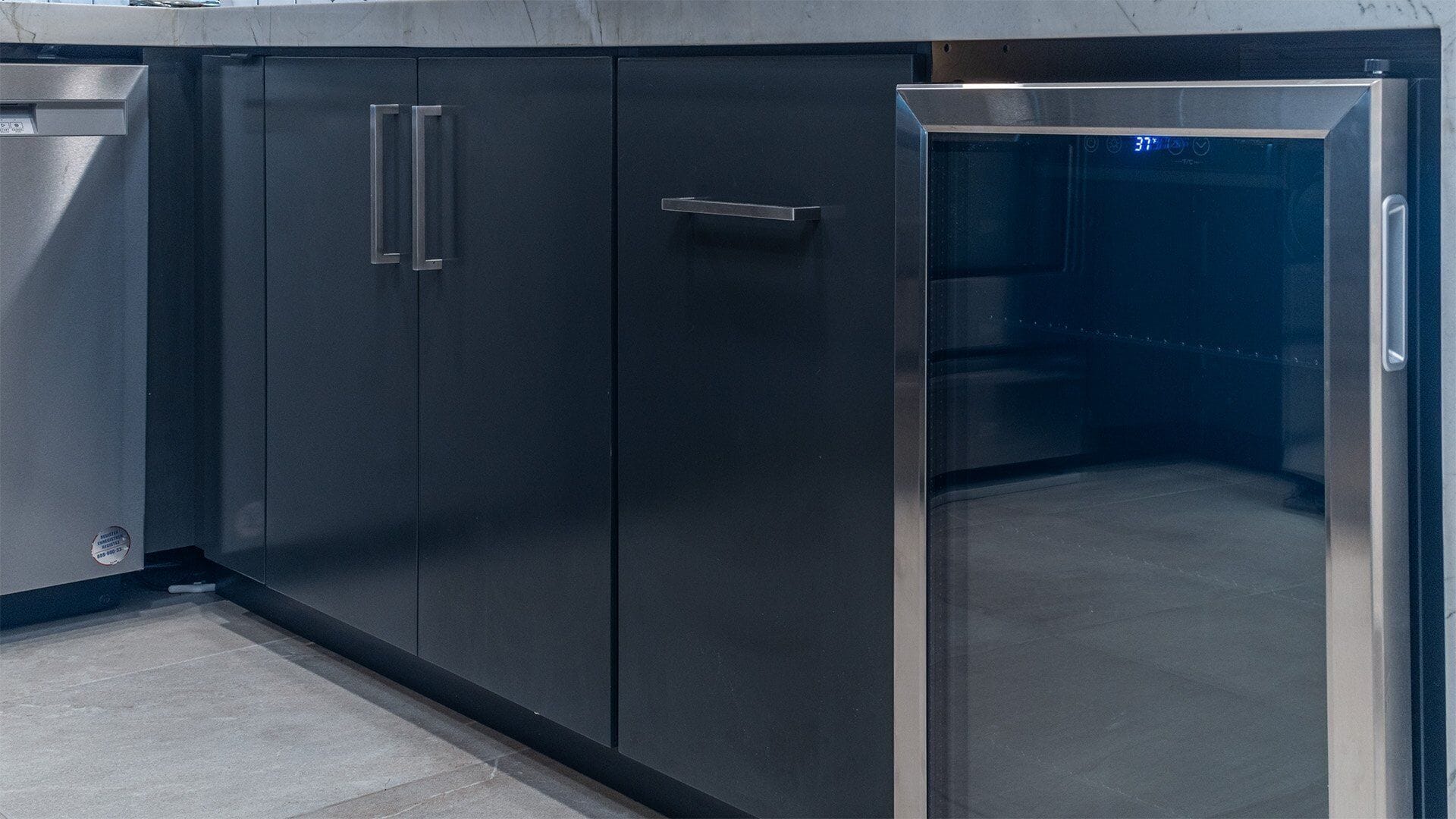 A modern kitchen with stainless steel appliances, including a refrigerator and a dishwasher.