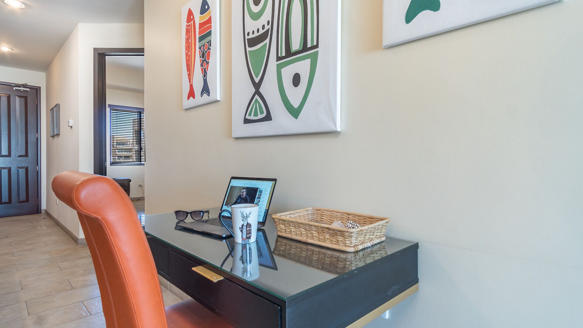 A modern office space with a desk, chair, laptop, and decorative items.
