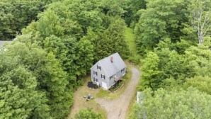 Una casa de dos pisos rodeada de un bosque frondoso.