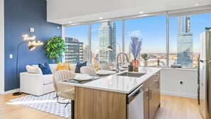 Una cocina moderna con una isla grande, electrodomésticos blancos y vistas a la ciudad.