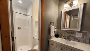 A bathroom with a shower, toilet, sink, and vanity. - Elk Haven Cabins - Cabin 4 (Payson)