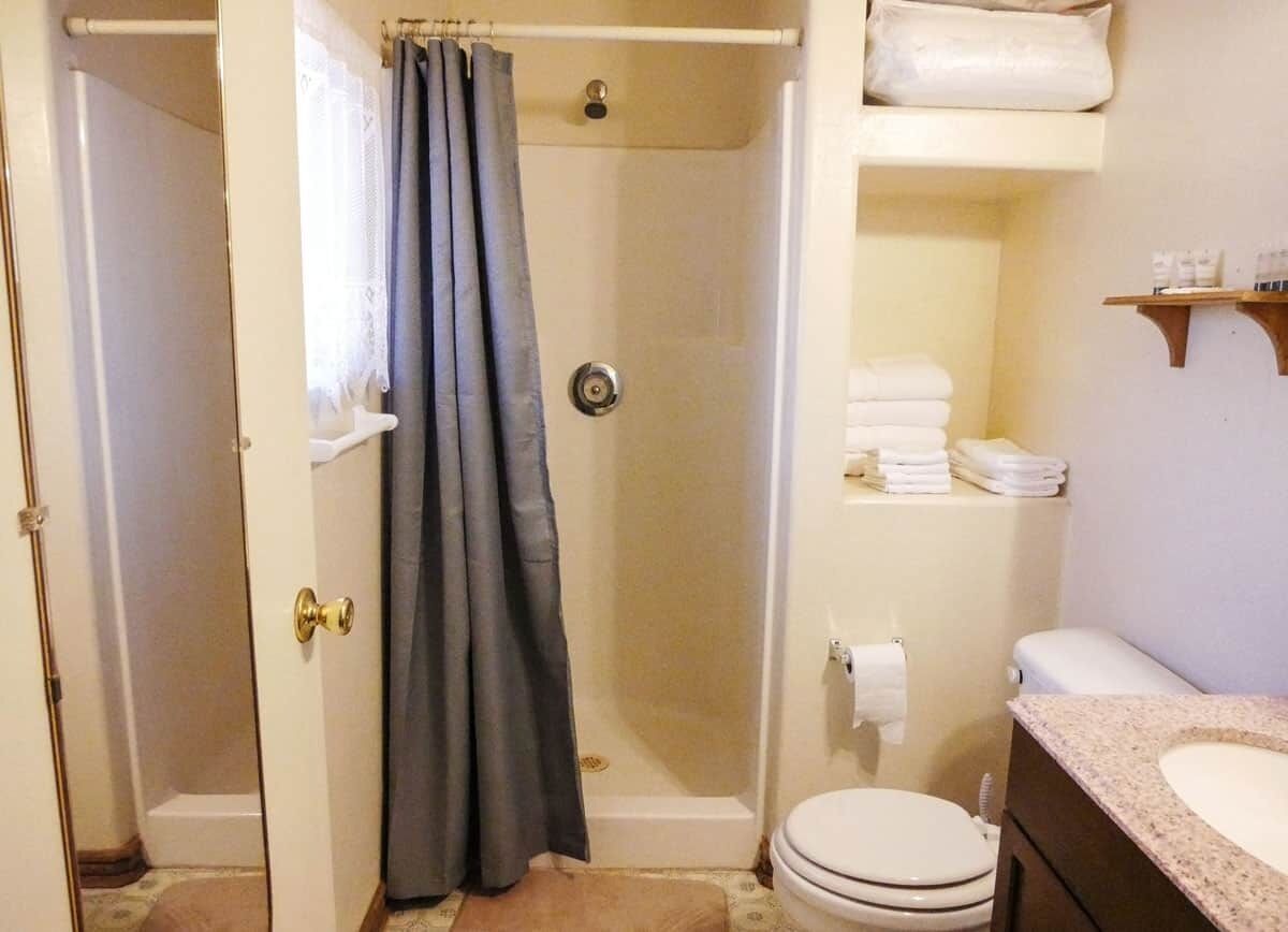 A bathroom with a shower, toilet, and sink.