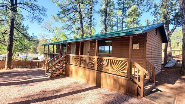 A wooden cabin with a covered porch and a staircase leading to the entrance. - Elk Haven Cabins - Cabin 2 (Payson)