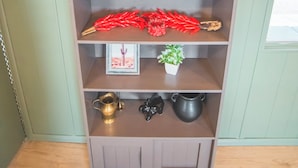 A wooden bookshelf with various decorative items including a fish, plants, and kitchenware. - Paula's Place Near The Lake (Elephant Butte)