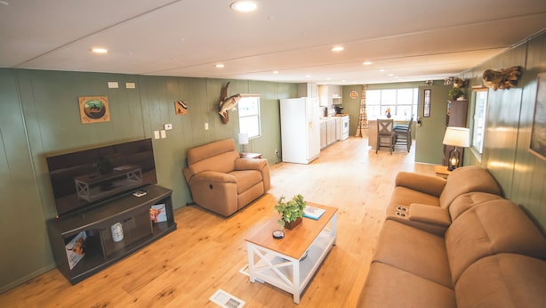 A spacious living area with a TV, sofa, and coffee table. - Paula's Place Near The Lake (Elephant Butte)