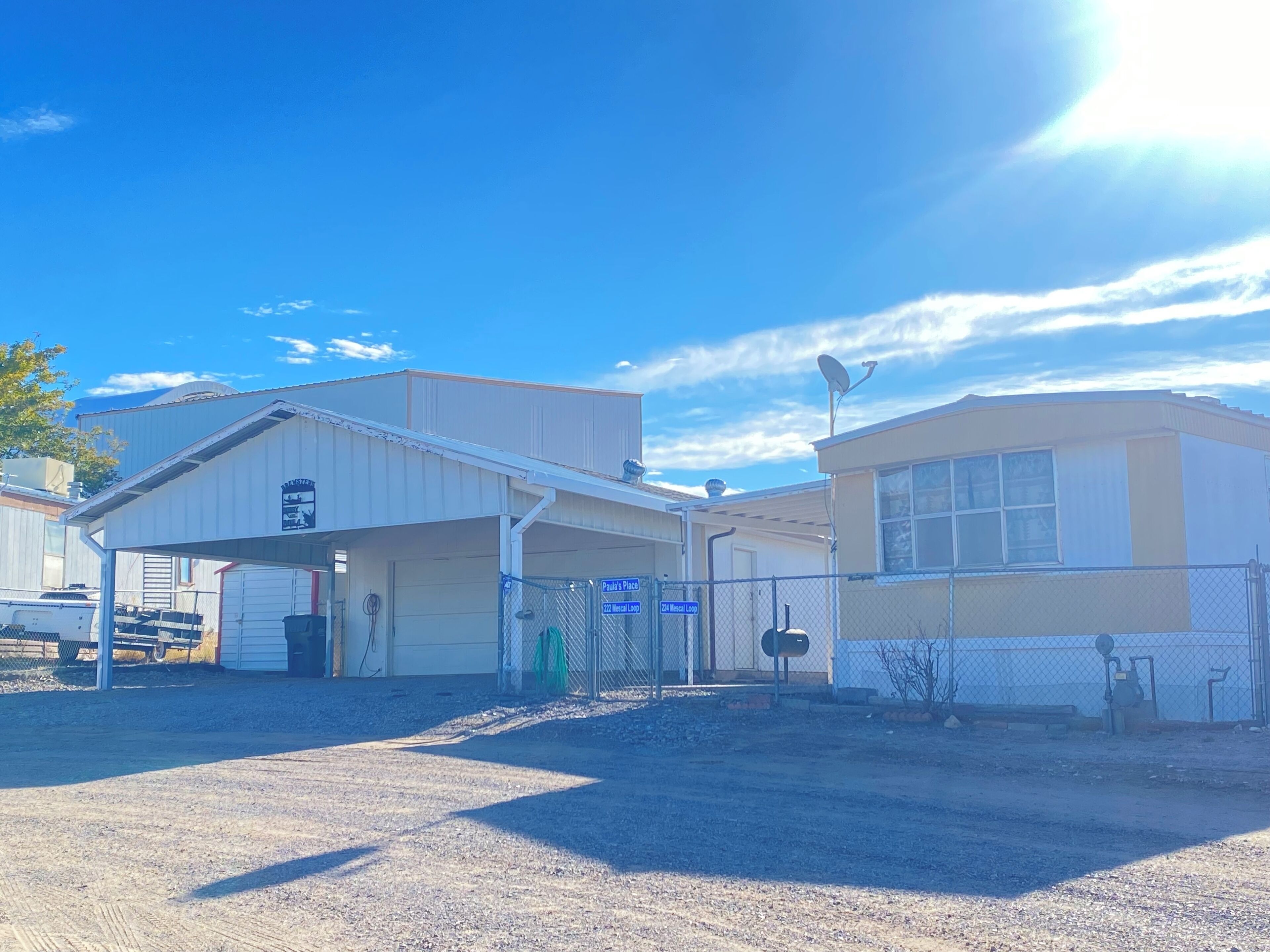 A commercial building with a covered loading dock, a fenced parking area, and a mailbox.