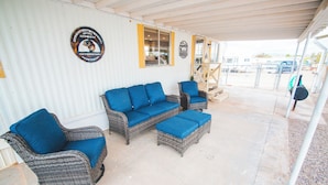A covered patio area with wicker furniture and a small outdoor kitchen. - Paula's Place Near The Lake (Elephant Butte)